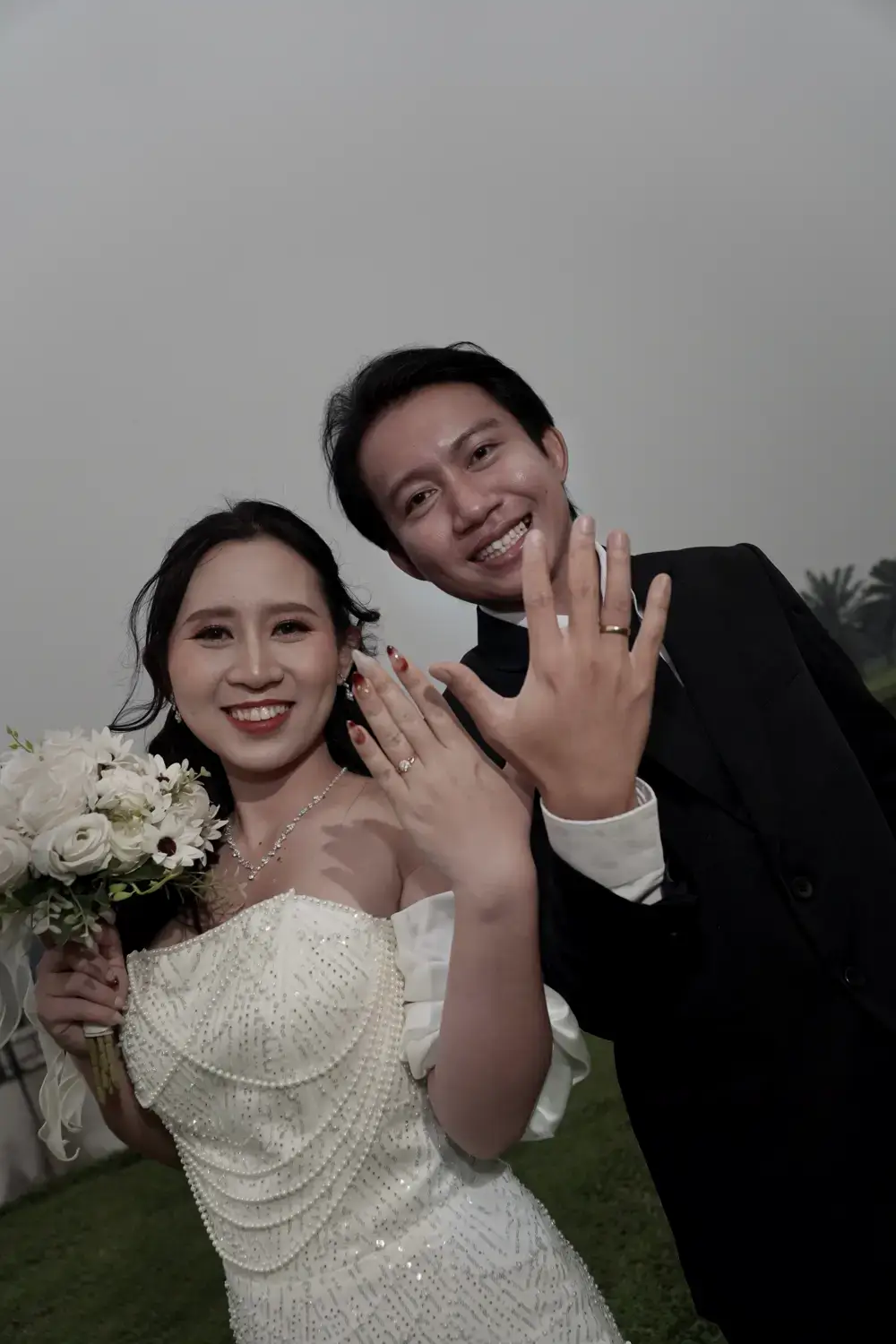 Andrew dan Putri tersenyum sambil memperlihatkan cincin.