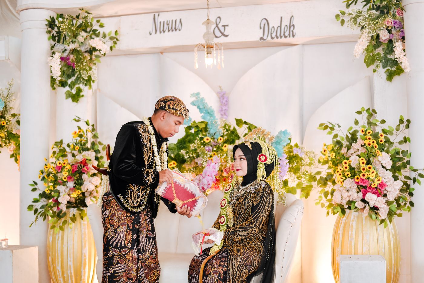 Pasangan di pelaminan berhias bunga