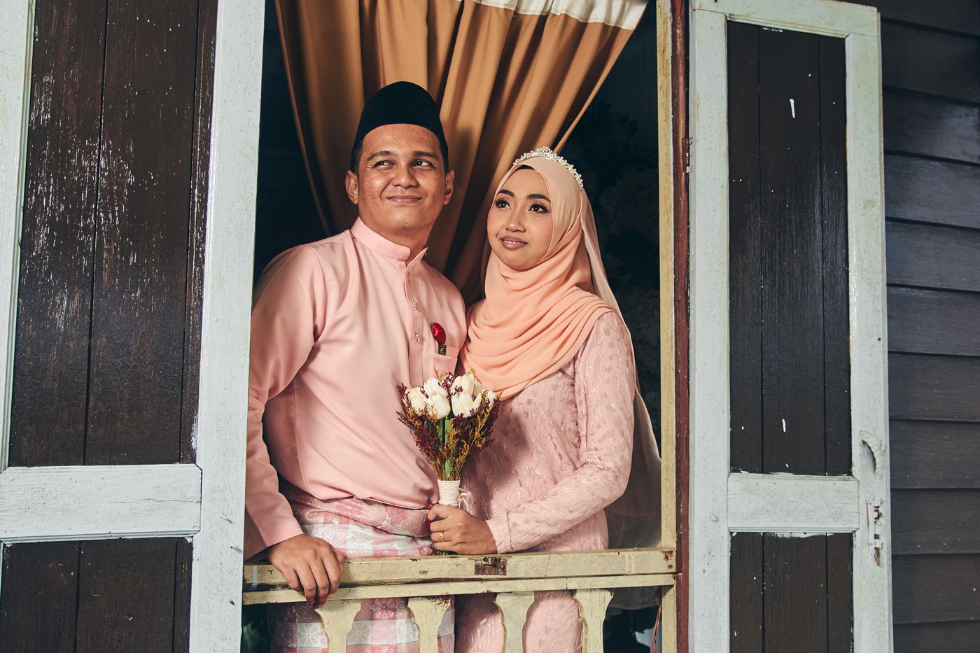 Pasangan duduk berdekatan di bingkai jendela kayu