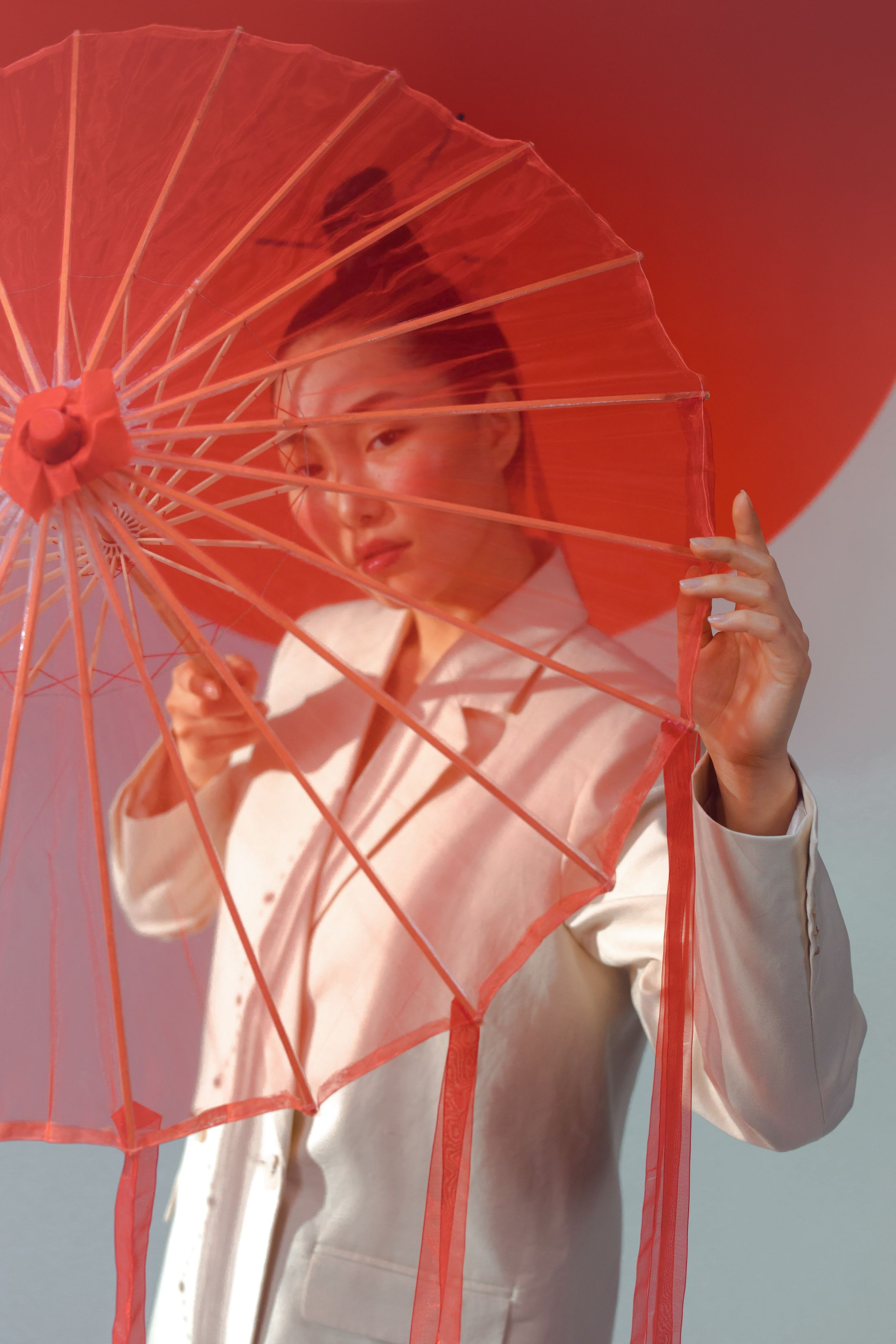 Model berbusana putih dengan payung merah