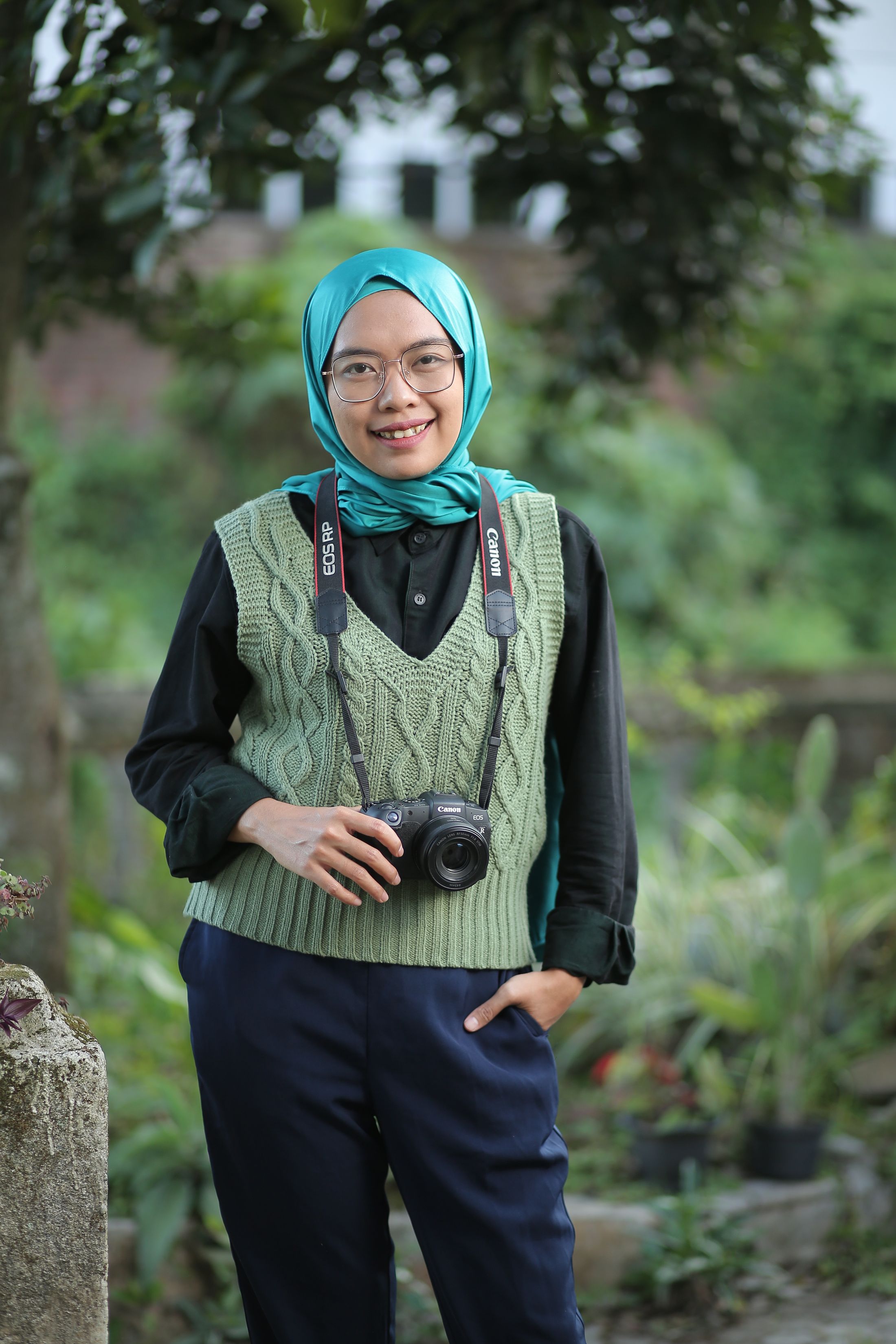 Sekar memegang kamera di kebun