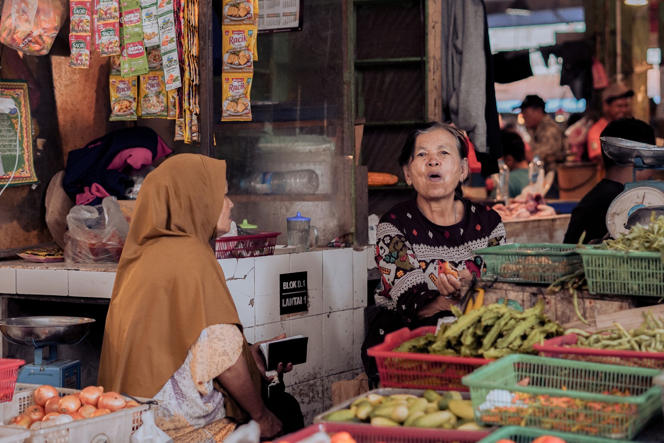 Dua pedagang melayani pembeli di lapak sayur