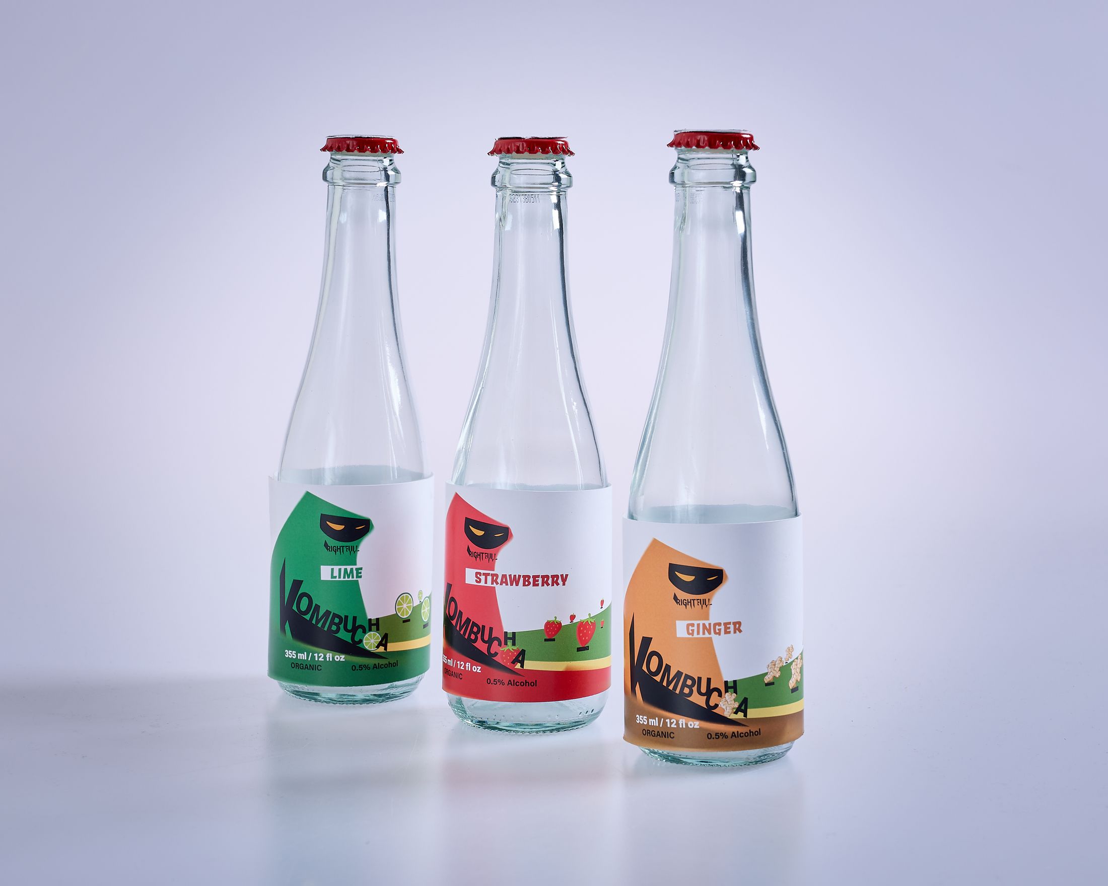 Tiga botol kombucha berlabel warna-warni