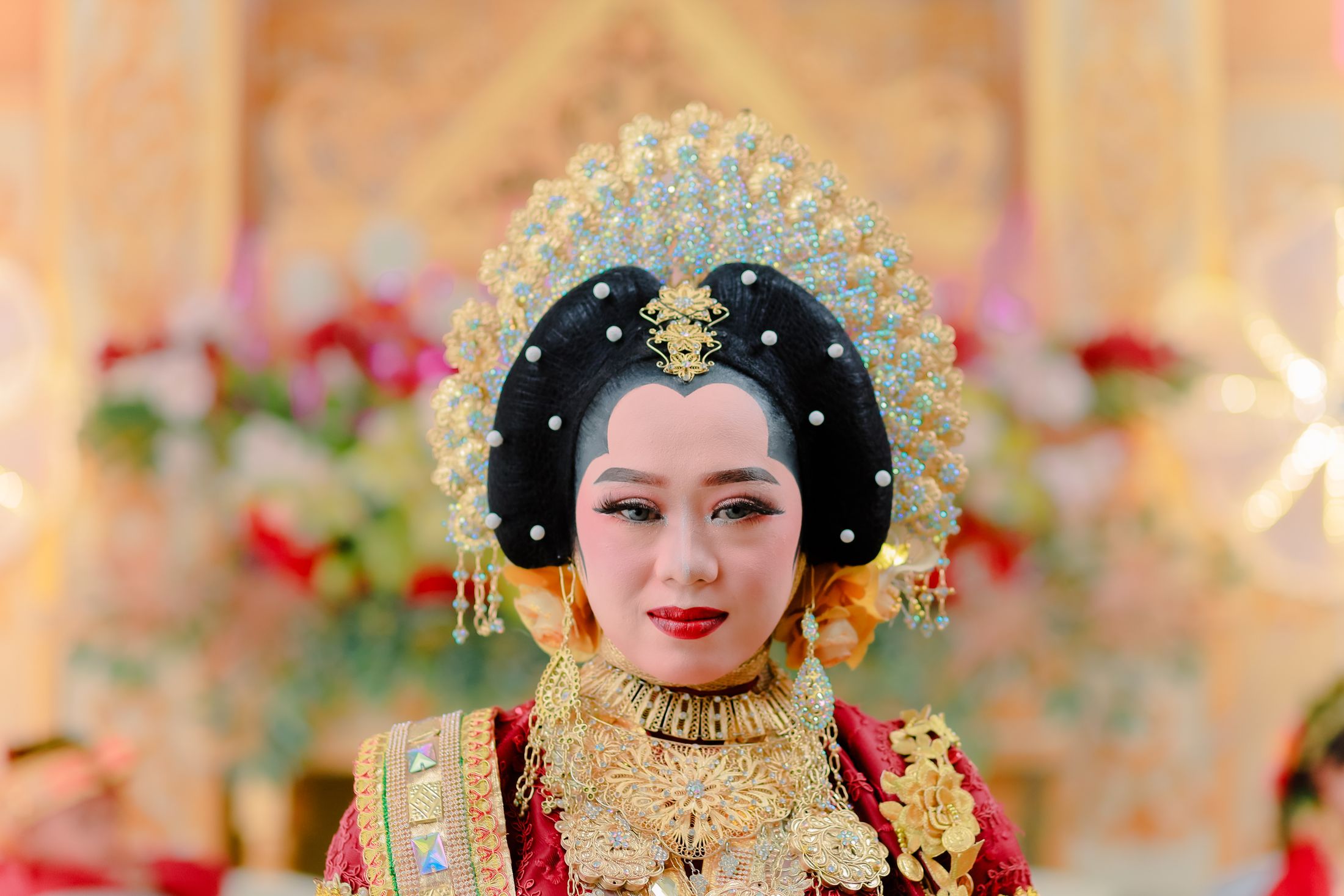 Pengantin berbusana merah dengan hiasan kepala