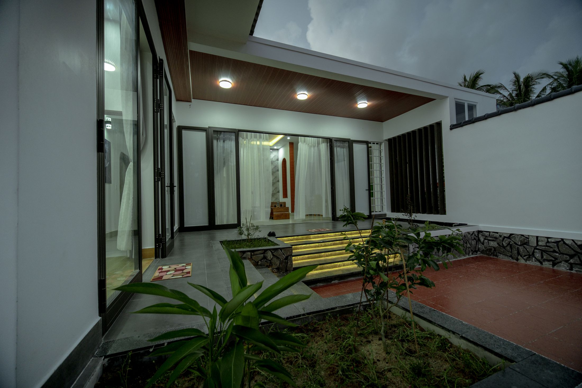 Teras rumah menghadap taman dalam saat senja