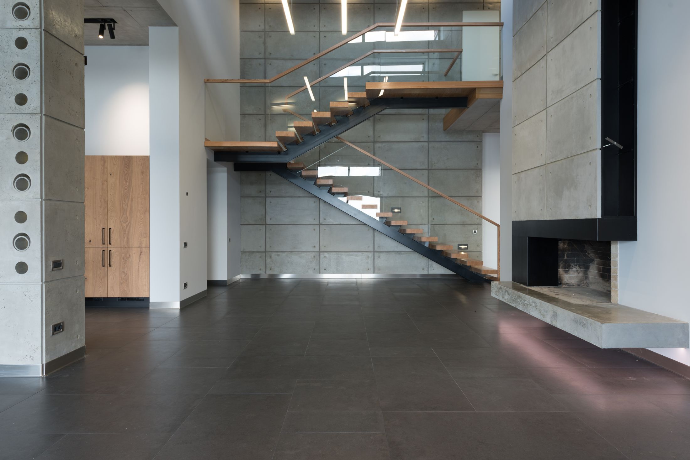 Ruang loft dengan dinding beton dan tangga kayu